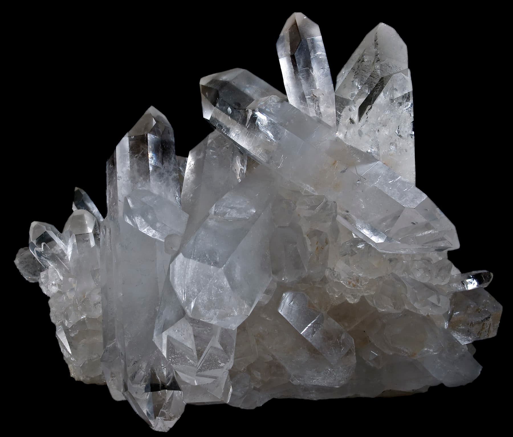 A cluster of clear quartz crystals against a black ground.