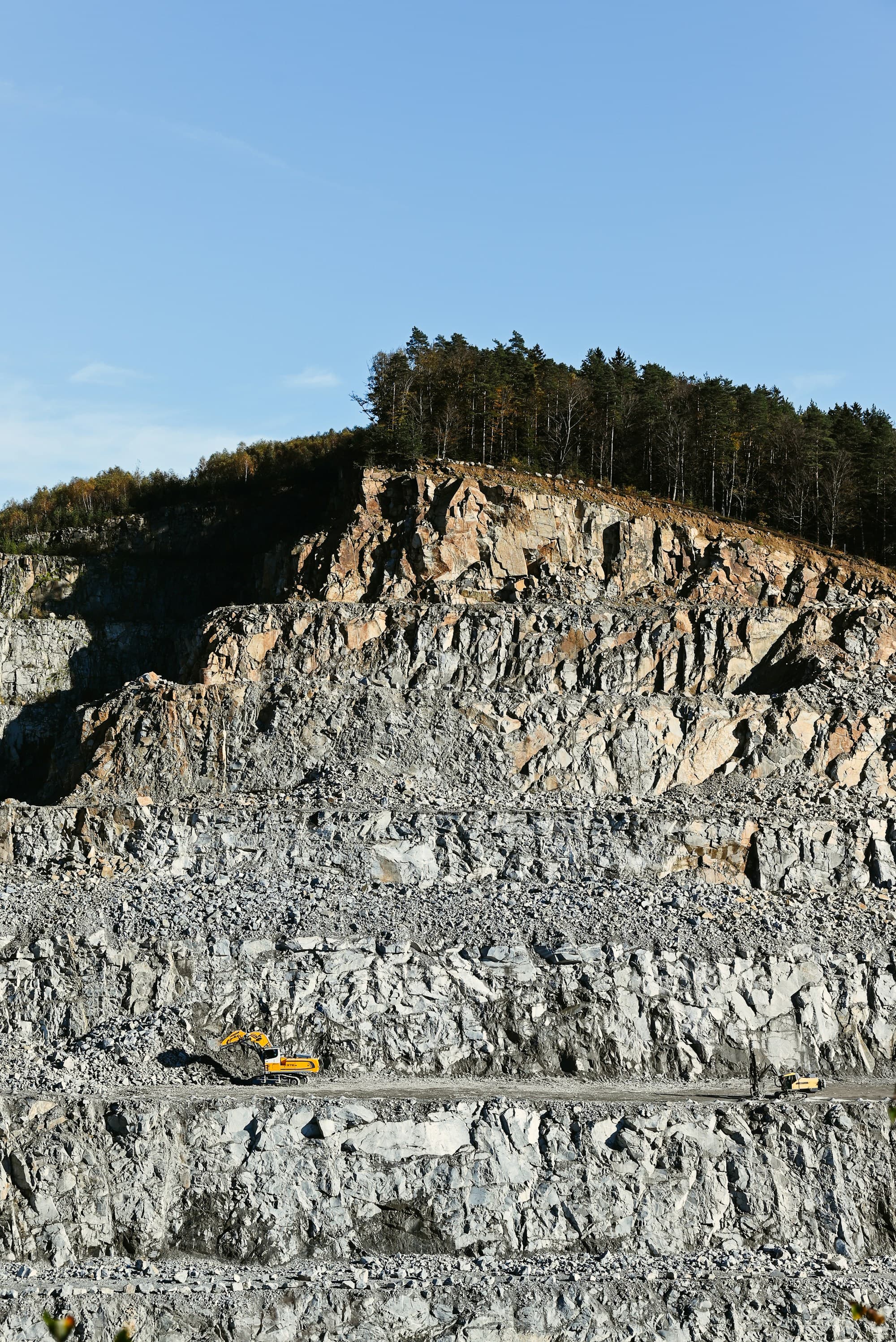 Granite quarry benches cut into a green mountain valley in Buner, Khyber Pakhtunkhwa